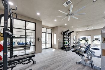 a home gym with a large window and a ceiling fan  at Carmel Creekside, Fort Worth, TX